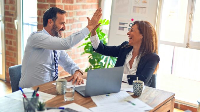 Devenez un winner des services entreprises : Stratégies et conseils pour réussir homme en chemise blanche assis à côté d'une femme en chemise noire à manches longues