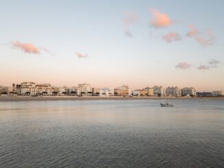 L'horizon de la ville rencontre la mer sous un ciel calme.